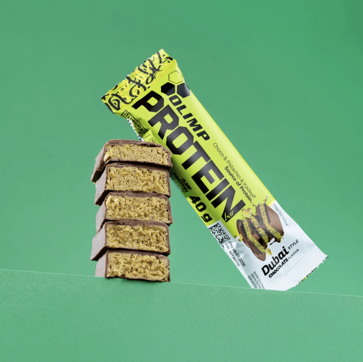 Olimp Protein Bar Dubai Style Chocolate Flavour: baton 40 g z przekrojem warstw pistacjowego nadzienia w mlecznej czekoladzie